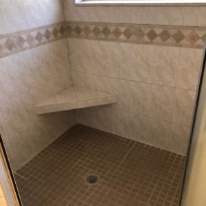 This image features a curbless shower with a seat. 