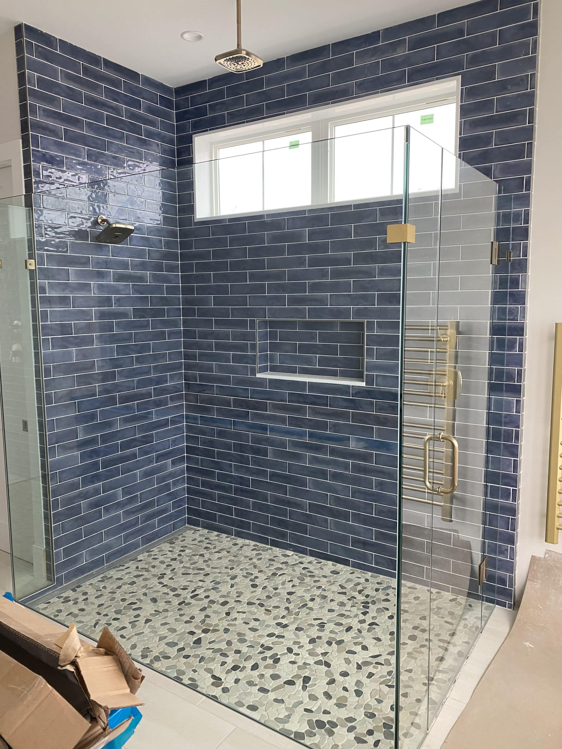 This image features a walk-in shower with grey tiling.